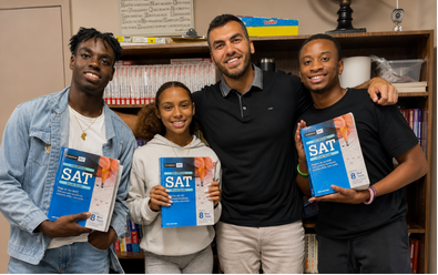 PROPEL students and a Top Score Tutors instructor holding SAT study guides