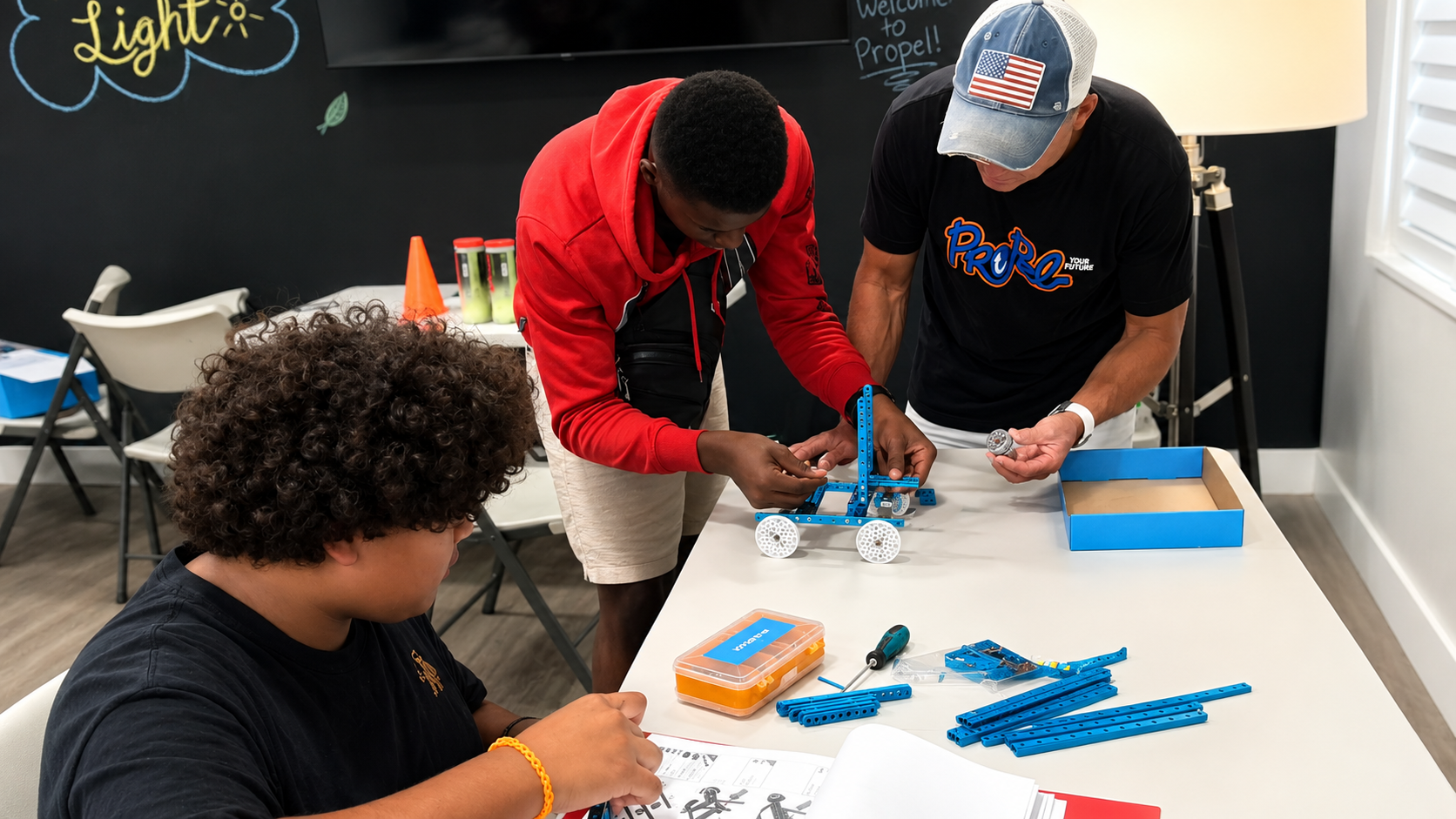 PROPEL students and a mentor building a robot together